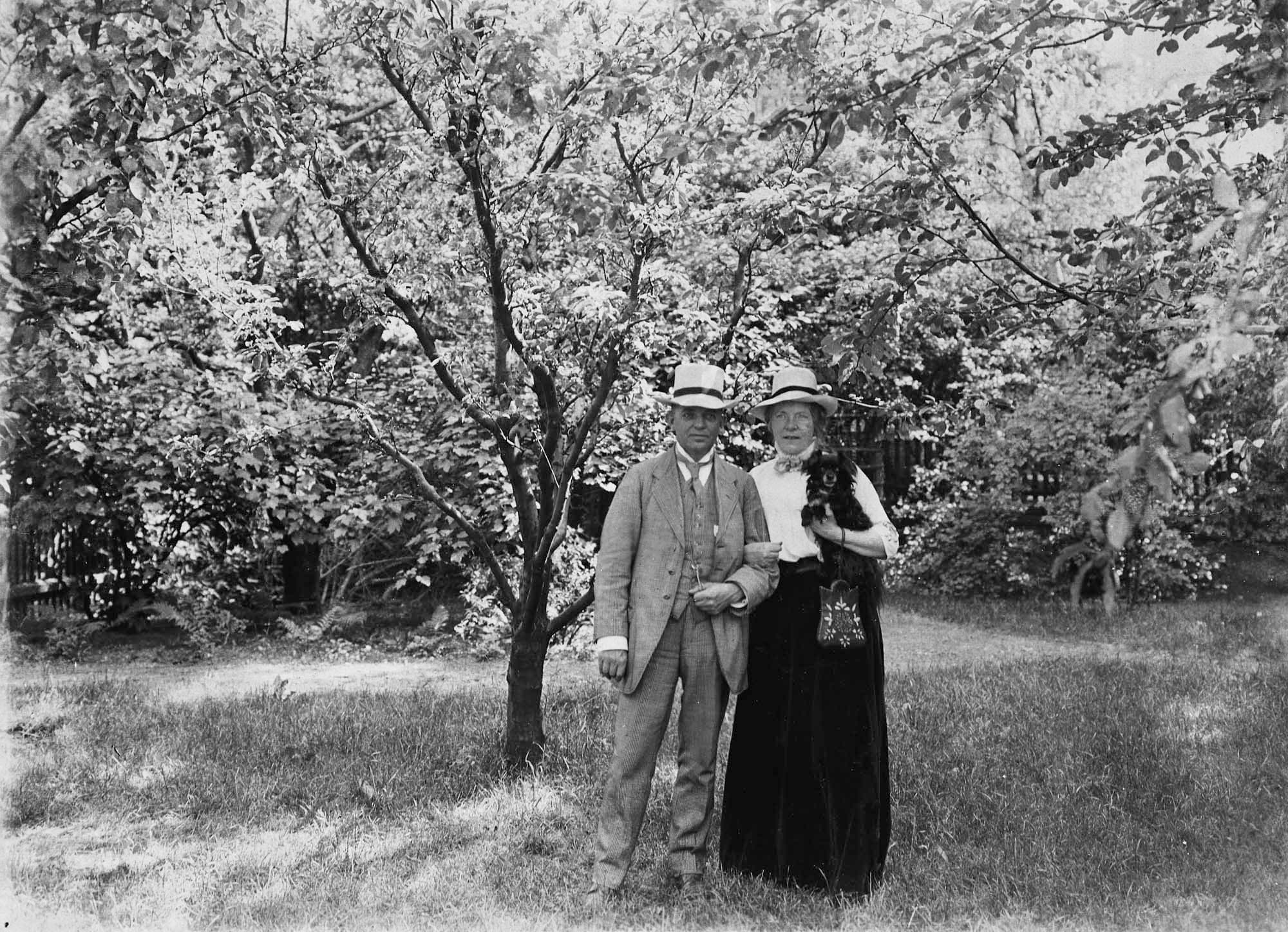 Mand og kone under frugttræet i haven på Vodroffsvej, den sidste med familiehunden Jutte i favnen.