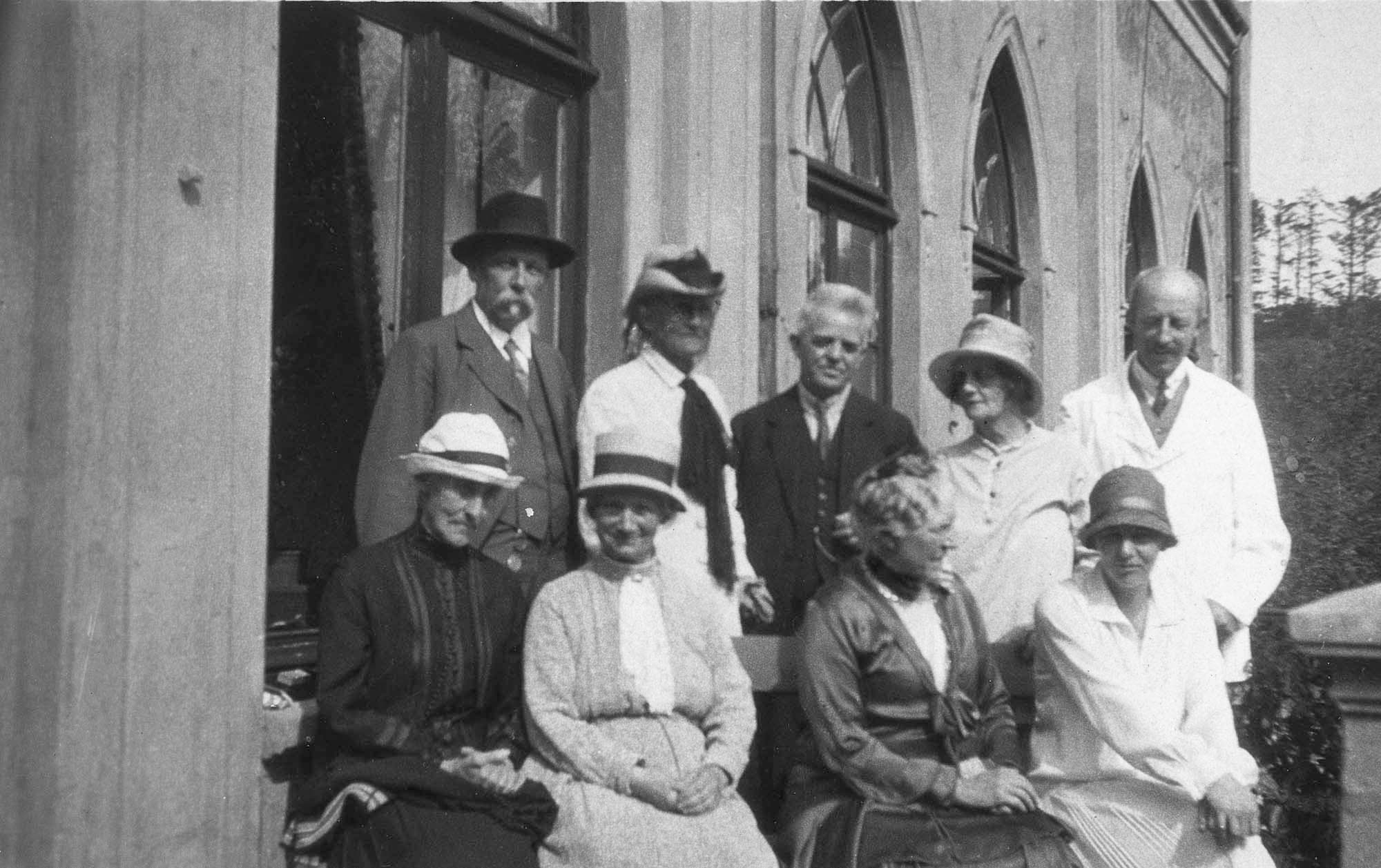 Damgaards terrasse: Cordt Trap og hans adoptivsøster Charlotte Trap de Thygeson, Carl Nielsen, Margrete Rosenberg og uidentificeret mand; siddende Therese Krüger og Jenny Theter (eller omvendt) samt Anne Marie Carl-Nielsen og Irmelin. Personkredsen taget i betragtning formentlig i begyndelsen af august 1925.