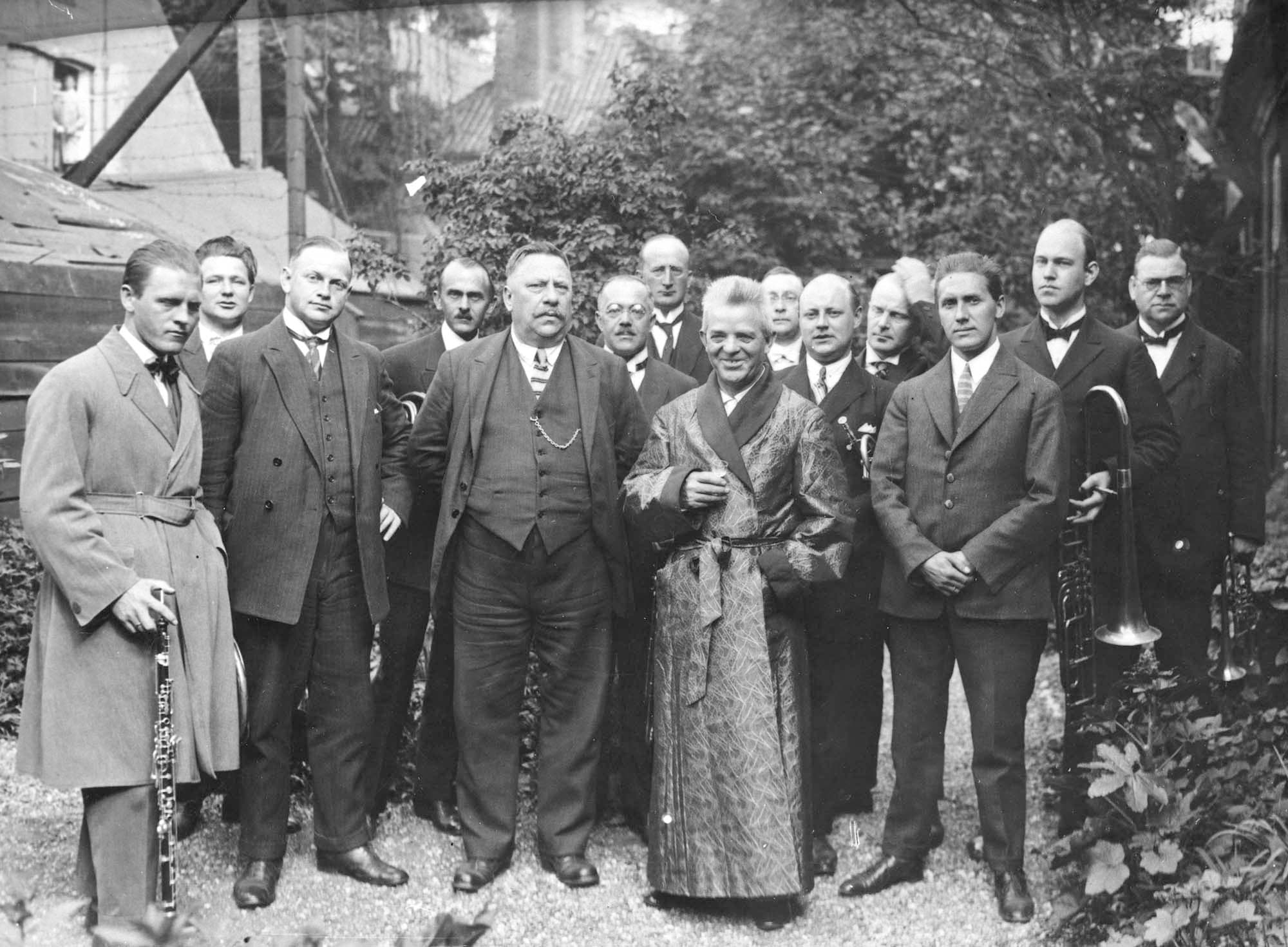 I haven omgivet af Københavns Orkesterforenings deputation, om morgenen den 9.6.1925. Til venstre for Carl Nielsen står basunisten August Petersen senior.