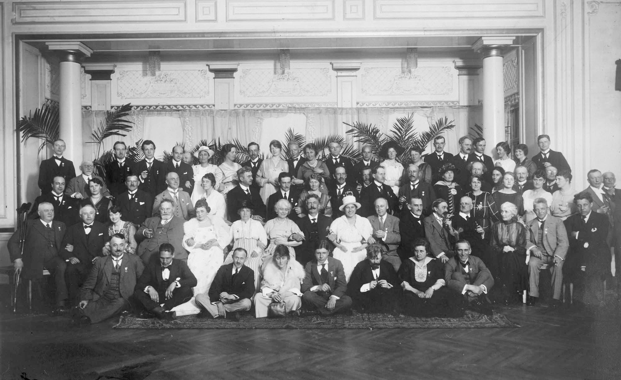 Afslutningsbanketten fredag 20.6.1919. På gulvet fra højre: Wilhelm Stenhammar, Gunna Breuning-Storm og Peder Møller. I 2. række fra venstre sidder nr. 4: Charles Kjerulff og midt i rækken: Johan Halvorsen. Samme række fra højre: Georg Høeberg, Carl Nielsen, Jean Sibelius, Fr. Schnedler-Petersen og Robert Kajanus.