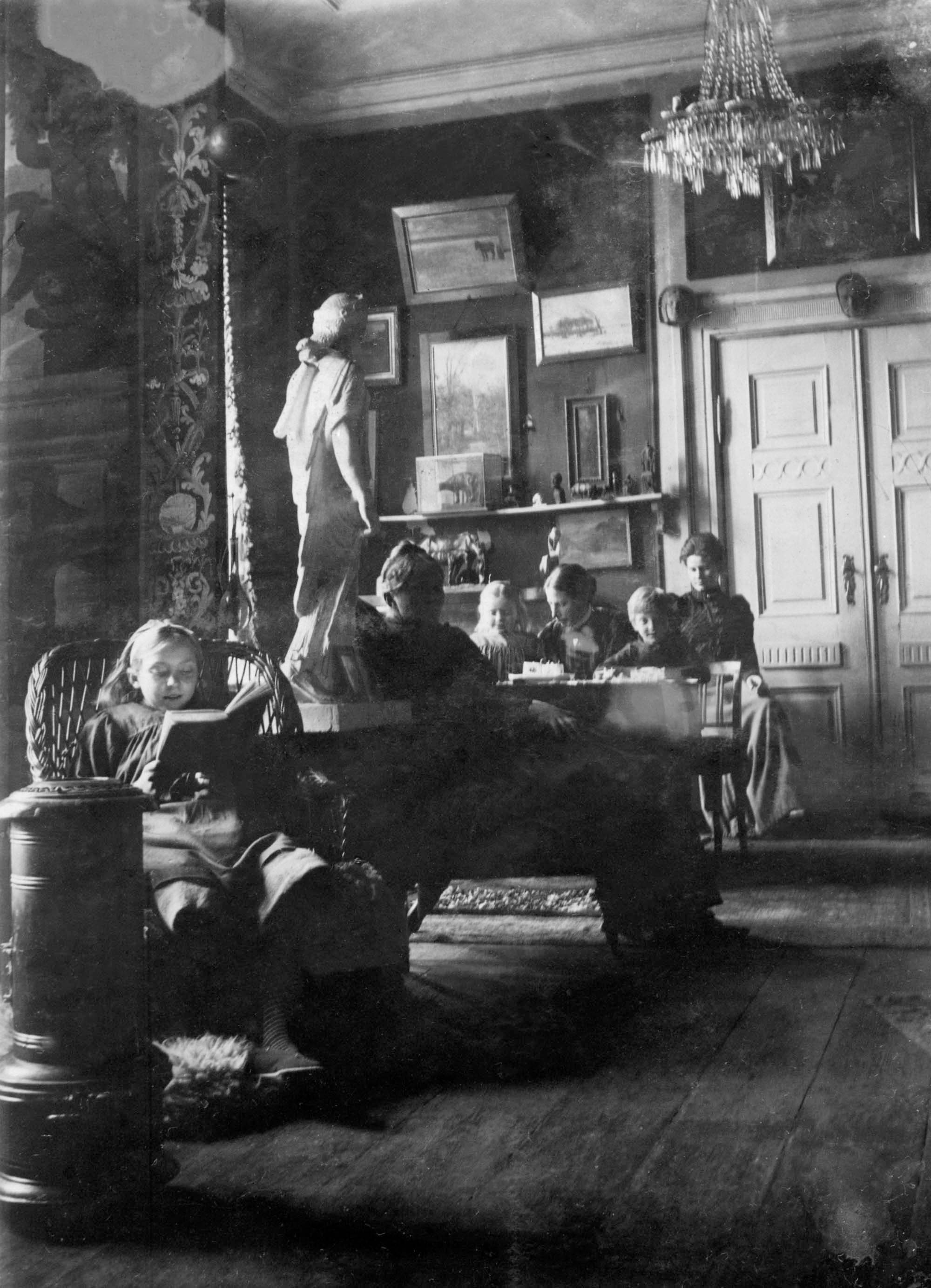 På billedet ses både Anne Marie Carl-Nielsen, Marie Møller og husholderen Maren Hansen, der blev ansat i januar 1904. Det må være taget samme år før husfruen i november rejste til Athen. På billedets bagside har Anne Marie Telmanyi, uden at nævne Marie Møller (som sidder mellem Søs og Hans Børge), mange år senere skrevet: “Forest min Søster antagelig 12 Aar, Moder i profil, min Broder og jeg, bagerst Maren som ung, taget paa Toldbodvej 6 i den store Stue.”